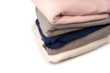 A group of warm sweaters isolated on a white background. Stack of folded sweaters on white...