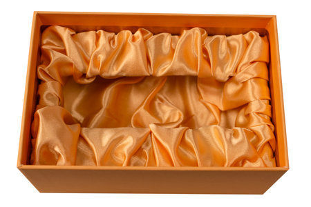 Orange empty gift box covered with orange satin fabric isolated on a white background. Top view.