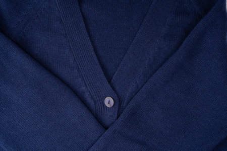 Navy blue merino wool cardigan texture as background. Top view.