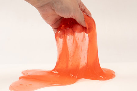 Red slime in hand isolated on white. Top view.の写真素材
