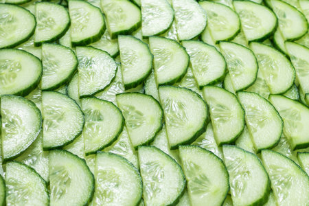 Fresh green slices of cucumber as background. Top view.の写真素材