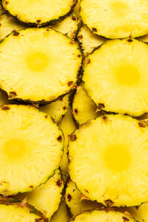 Pineapple juicy yellow slices background. Top view.の写真素材