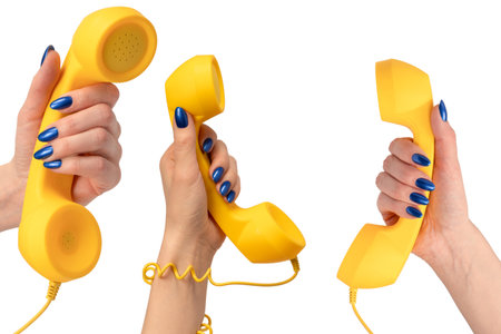 Yellow handset in woman hand isolated on white. Copy space.の写真素材