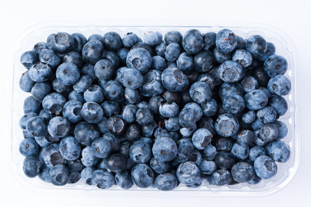 Blueberries in a plastic container isolated on a white background. Top view.の写真素材