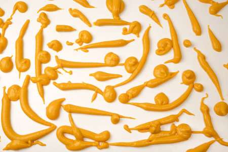 Yellow sauce splashes as a background. Top view.の写真素材