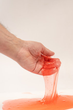 Red slime in hand isolated on white. Top view.の写真素材