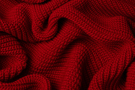 Red sweater texture as a background. Top view