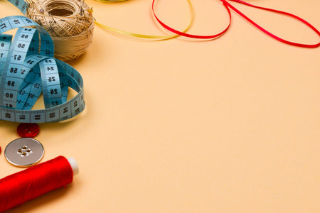 Threads, buttons, red fabric, measuring tape. Copy space.