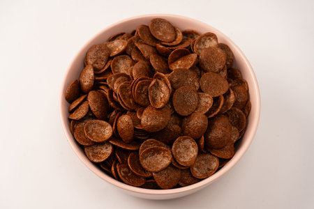 Corn-flakes in a bowl isolated on a white background. Chocolate cereal.