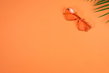 Pink sunglasses and a hat on orange background. Copy space.の写真素材