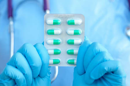 female doctor holding medicine capsules