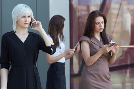businesswomen whith  tablets and phones on the streetの写真素材
