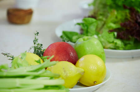 apples, lemons, peppers on a plateの写真素材
