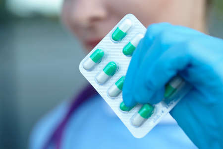 female doctor holding medicine capsules