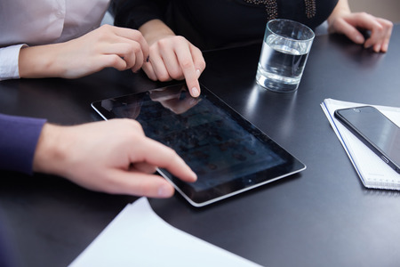 hand a group of businessmen on a table with a tablet, mobile phone