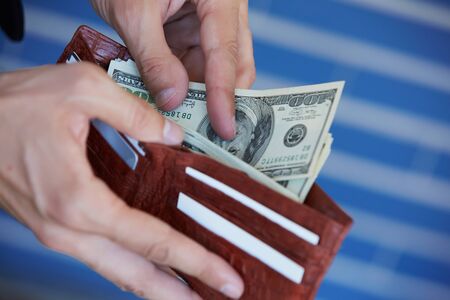 man holding a purse with money closeup