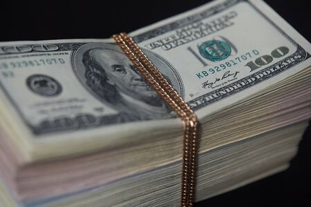 a bundle of money tied with gold chainの写真素材