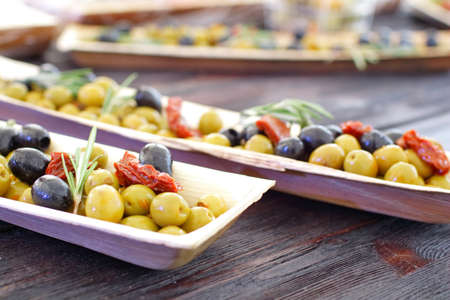 black and green olives, herbs, sun-dried tomatoes in an oblong dishの写真素材