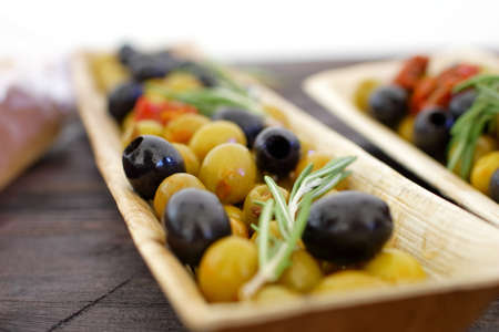 black and green olives, herbs, sun-dried tomatoes in an oblong dishの写真素材