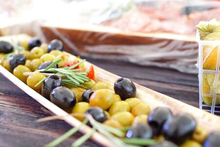 black and green olives, herbs, sun-dried tomatoes in an oblong dishの写真素材