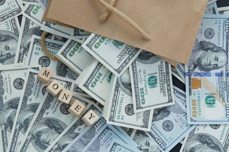 Wooden blocks - the inscription money. a lot of money out of a paper bagの写真素材