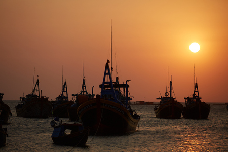 fishing boats in the sea at sunsetの写真素材