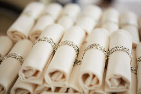 many curled napkins with rings in a restaurantの写真素材