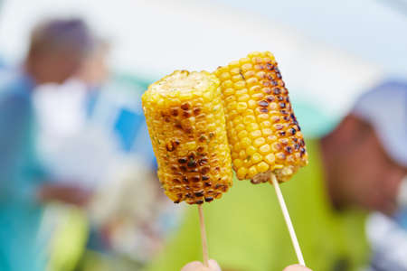 holding corn on skewersの写真素材