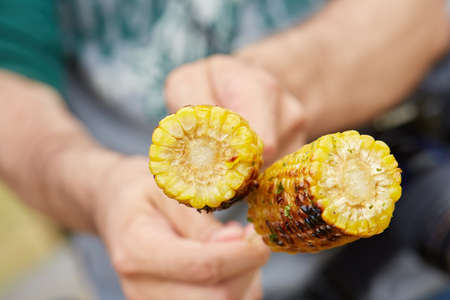 holding corn on skewersの写真素材