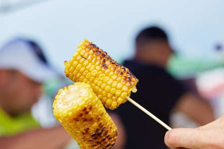 holding corn on skewersの写真素材