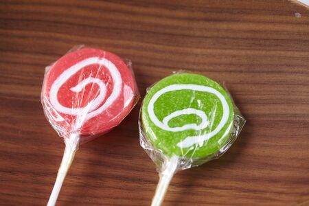 candy on a stick on a wood backgroundの写真素材
