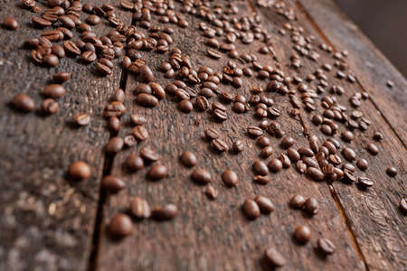coffee beans scattered on the wooden tableの写真素材