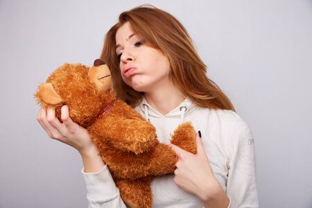 red-haired woman with a teddy bearの写真素材