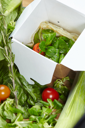 vegetarian vegan vegetable dish, fresh herbs in a cardboard boxの写真素材