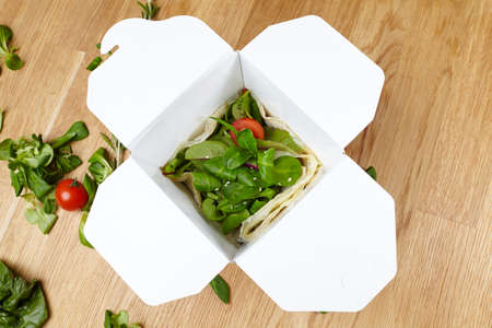 vegetarian vegan vegetable dish, fresh herbs in a cardboard boxの写真素材