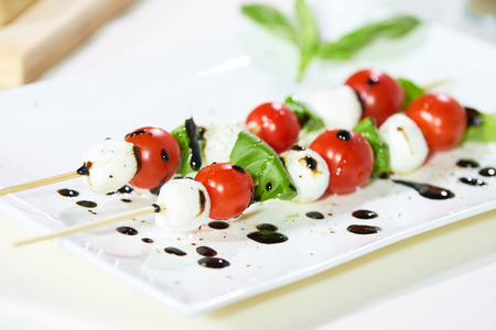 appetizer of cherry tomatoes, mozzarella, basil and sauceの写真素材