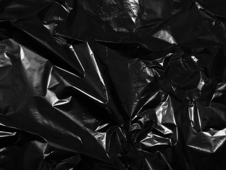 Black plastic bag texture background. Close up of crumpled polyethylene film.の写真素材