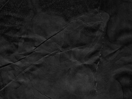 Black creased crumpled paper background grunge texture backdrop.の写真素材
