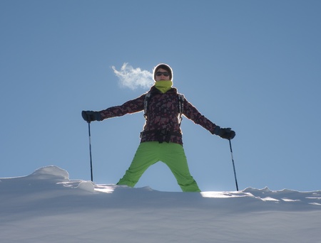 A girl in a ski suit against the skyの写真素材