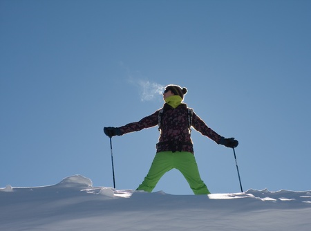 A girl in a ski suit against the skyの写真素材