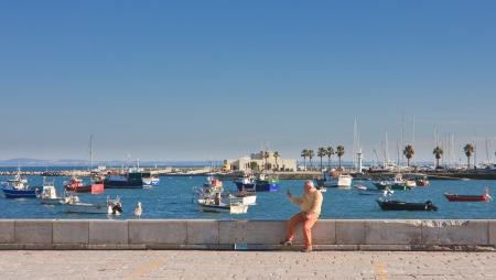 Man photographs seagull on the waterfront. Cascais. Portugal 