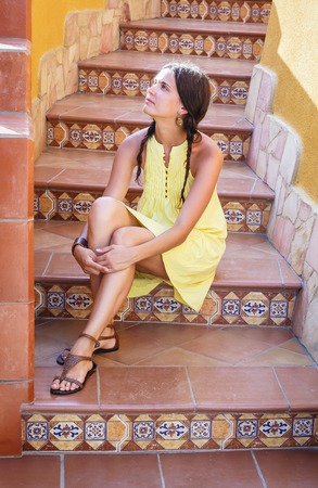 Beautiful girl on the stairs decorated with ceramic tiles. Sicily. Italyの写真素材