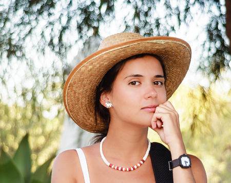 Portrait of a beautiful young brunette in a straw hatの写真素材