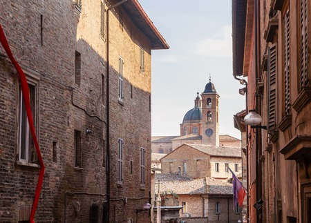 Old street in the Italian city of Urbino in the background of the Palace of the Dukes of Urbino and...