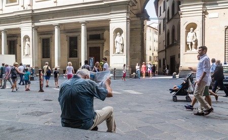 Unknown man is reading newspaper on Piazzale Degli Uffizi, Florence, Tuscany, Italyのeditorial素材