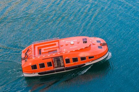 A tender is carrying passengers from a cruise liner to Olden pier on the Innvikfjorden in Norway...
