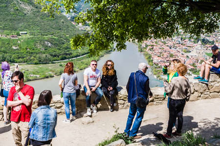 Tourists on the observation deck near the monastery of Jvari. Town Mtskheta in the background....