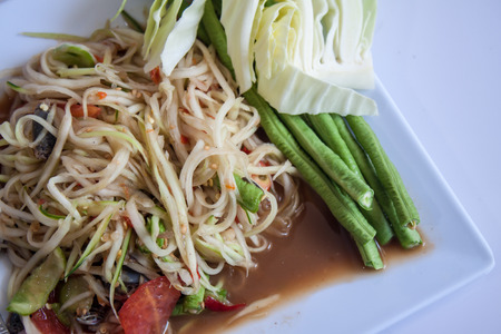 Papaya Salad, Thai call "Som tum" the most famous thai salad combination of green papaya, green beans, carrots, garlic, fresh chili, cherry tomatoes and carrots with sliced fresh lettuceの写真素材
