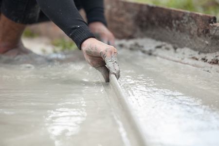 labor plastering cement with trowel for build new floor for renovation houseの写真素材