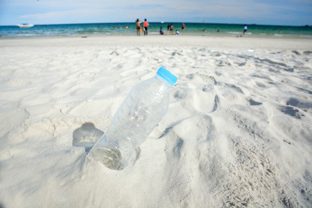 bottle placed on a sand dune in front of beautiful azure seaの写真素材